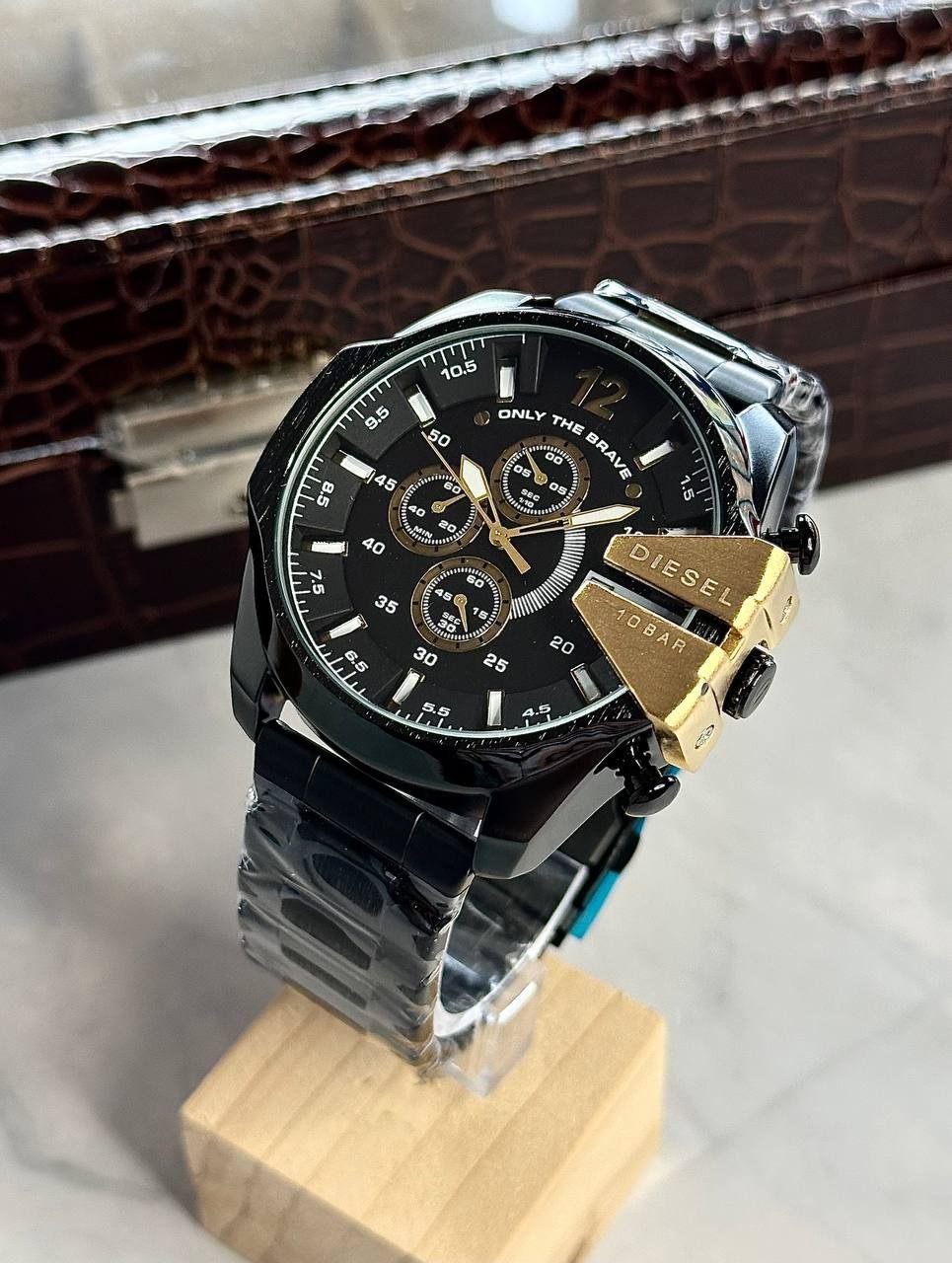 Diesel Mega Chief Chronograph — All-Black Ion-Plated Stainless Steel Case with Black Dial, Gold-Tone Accent Guard, Chronograph Sub-Dials, Date Window, and Matching Black Bracelet Hover