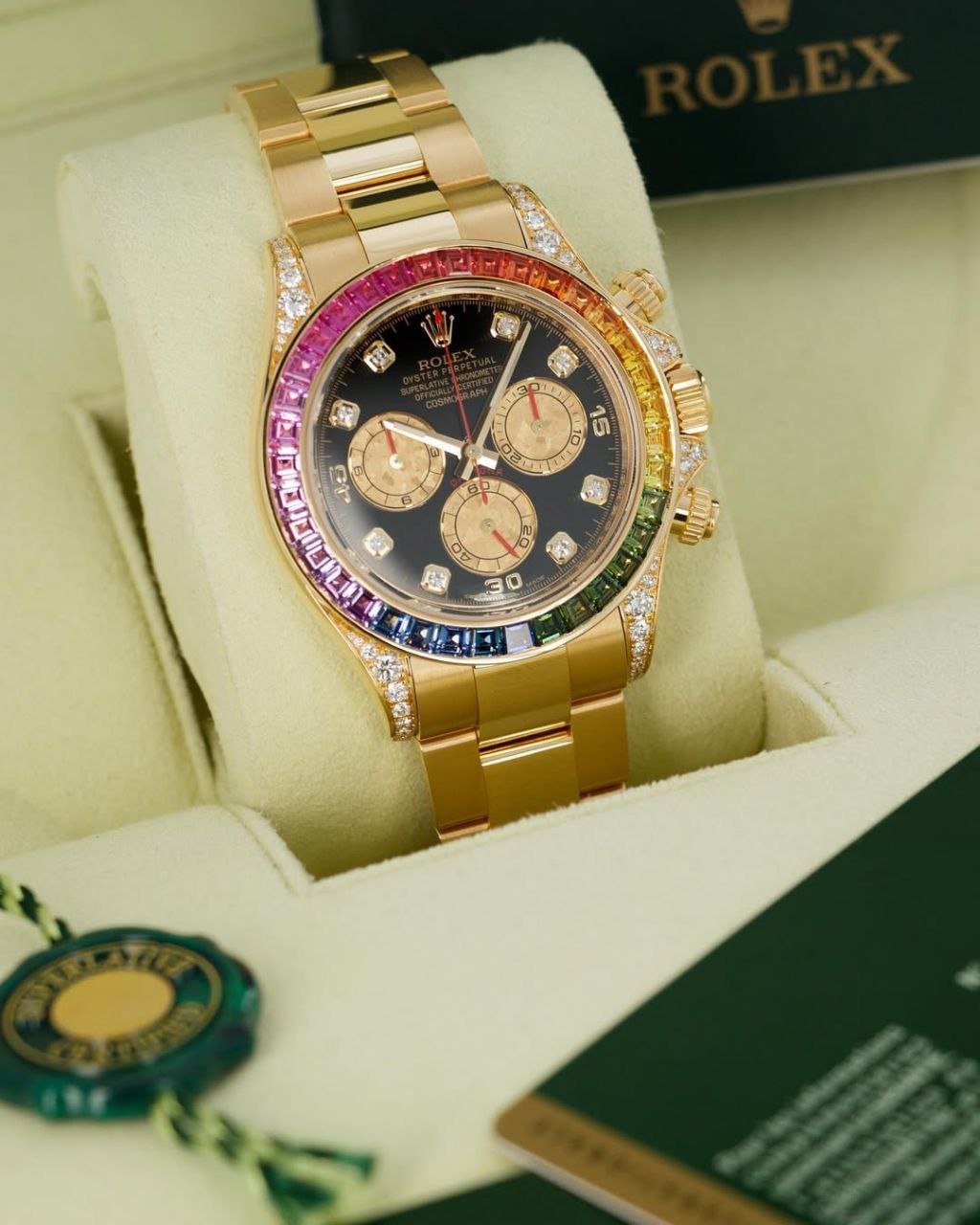 Rolex Cosmograph Daytona "Rainbow" (18 ct Yellow Gold) — 18 ct Yellow Gold Case with Diamond-Paved Lugs, Rainbow Sapphire Bezel, Black Lacquer Dial with Diamond Markers, and Oyster Bracelet Hover